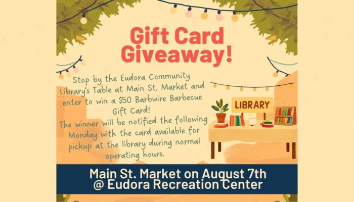 Main St Market Library Gift Card Giveaway (Website) announcing a gift card giveaway for those who stop by the Eudora Community Library's Main St. Market Table, $50 Barbwire Barbecue Gift Card. Main St. Market on August 7th at Eudora Recreation Center. Background features lights, leaves, a table that says library with books on it.